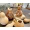 Unfinished dried gourds sitting next to finished gourd vases. They Feature butterflies and a sea turtle artwork drawn on the front.